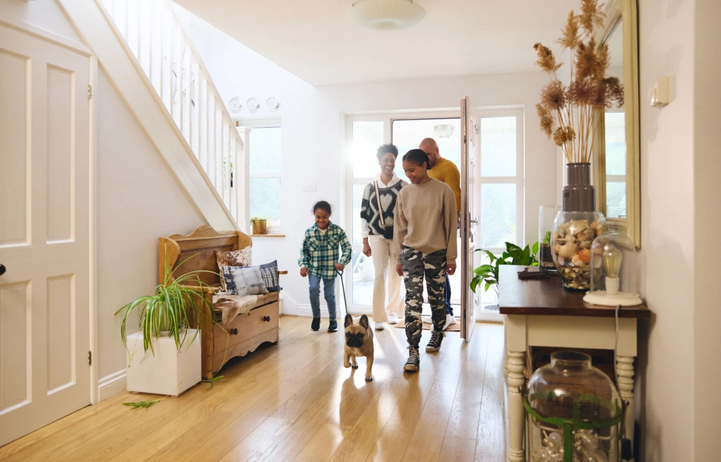 Family entering home with small dog.